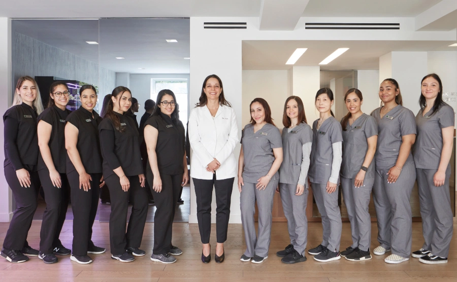 New York orthodontist and dental team posing together in modern office.